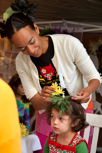 Edisa weaves flowers into a child's hair, 2009, photo by Fred Hatt